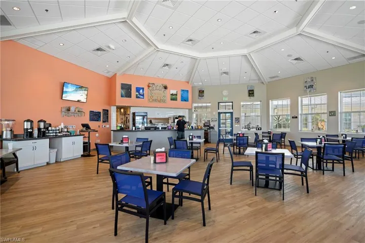 Dining space featuring light wood-style floors, visible vents, and a high ceiling