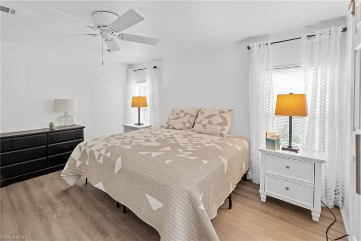 Bedroom with visible vents, a ceiling fan, and wood finished floors