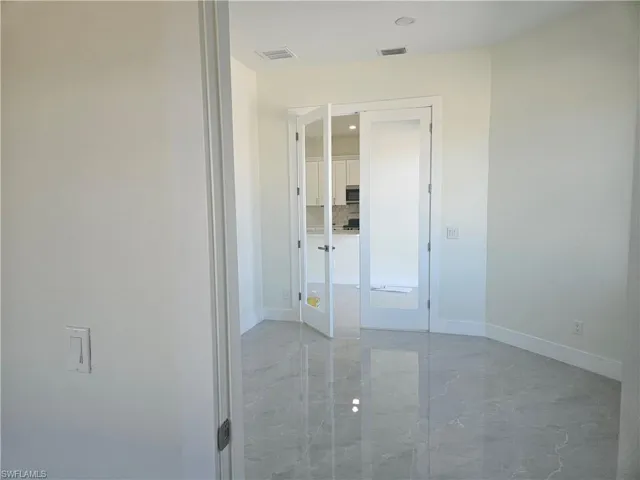 Unfurnished bedroom featuring light marble finish flooring and baseboards