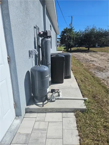 Exterior view of stucco siding and a water softener