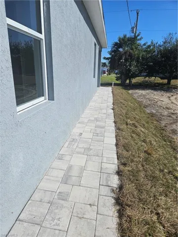 View of side of home with stucco siding and a lawn