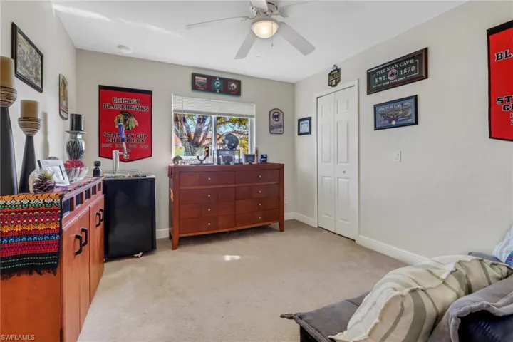 Carpeted bedroom with a closet and ceiling fan