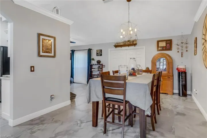 Dining area with crown molding and a notable chandelier