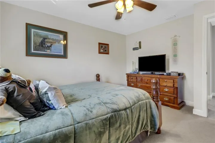 Bedroom with light carpet and ceiling fan