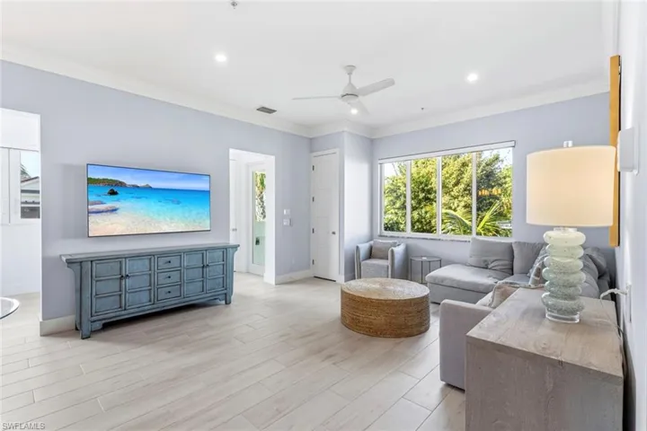 Living room featuring light Ceramic Tile floors, recessed lighting, crown molding, and ceiling fan