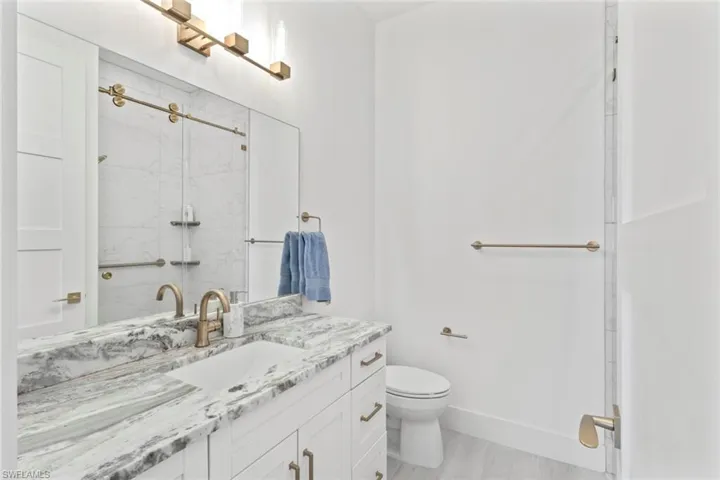 Full bathroom with vanity and a marble finish shower