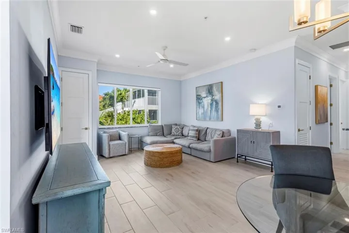 Living room with light Ceramic Tile flooring, ceiling fan, crown molding, and recessed lighting