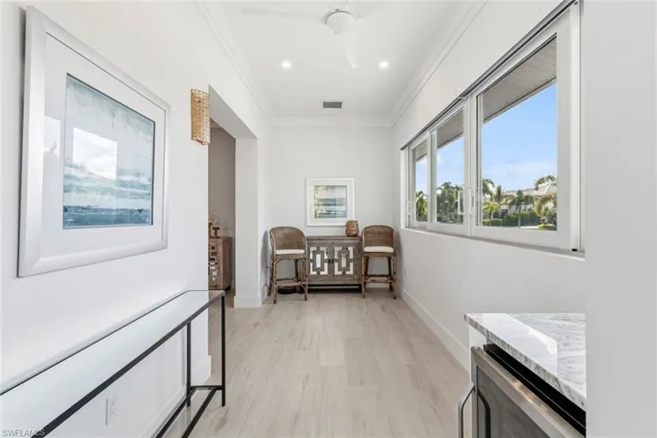 Hall featuring light Ceramic Tile floors, crown molding, and recessed lighting