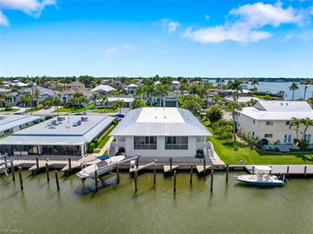 Aerial view of residential featuring Canal and boat slip and deck