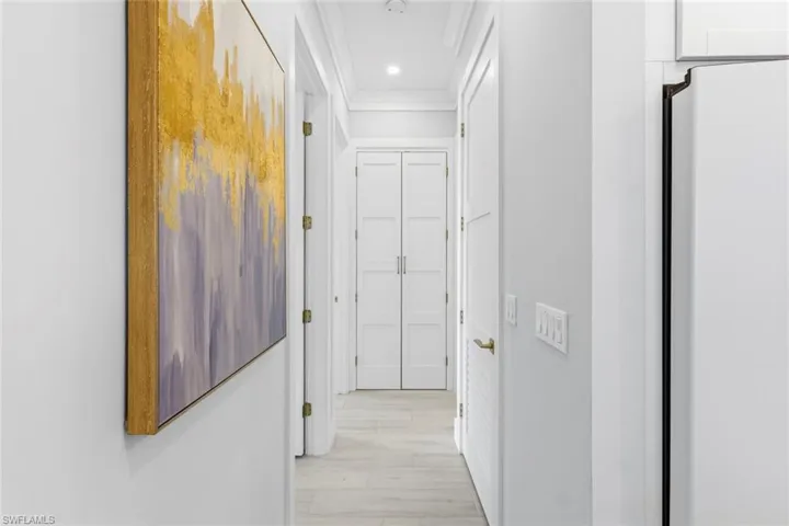 Hallway with crown molding and recessed lighting