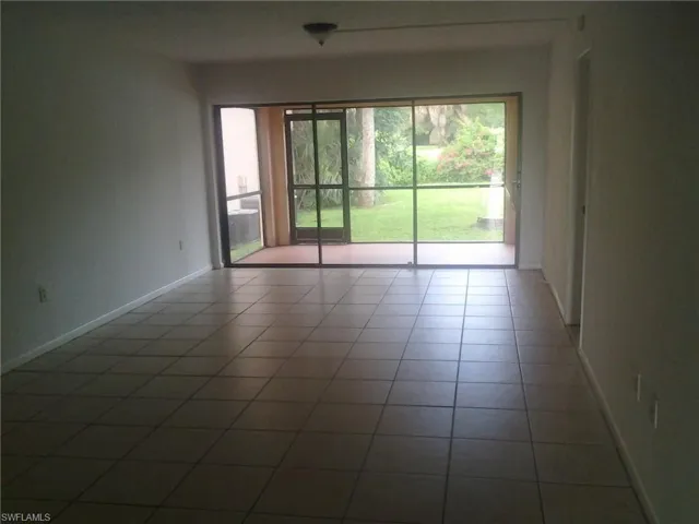 Tiled spare room featuring a healthy amount of sunlight