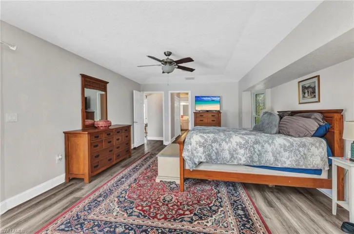 Bedroom featuring visible vents, baseboards, wood finished floors, and a ceiling fan
