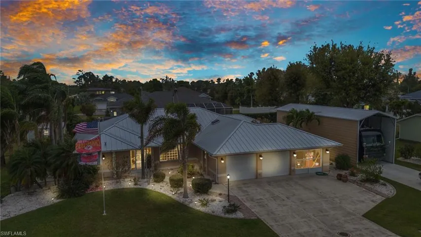 View of front of property with concrete driveway, a garage, and metal roof