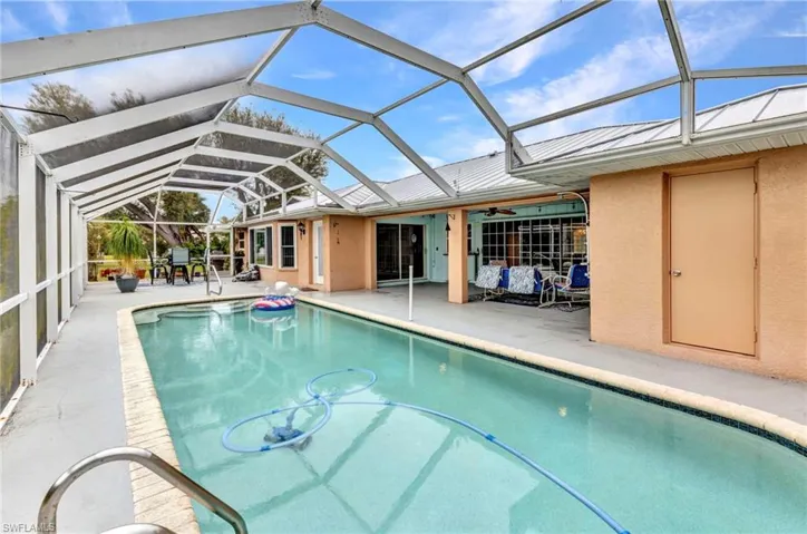Outdoor pool with glass enclosure, a patio, and ceiling fan
