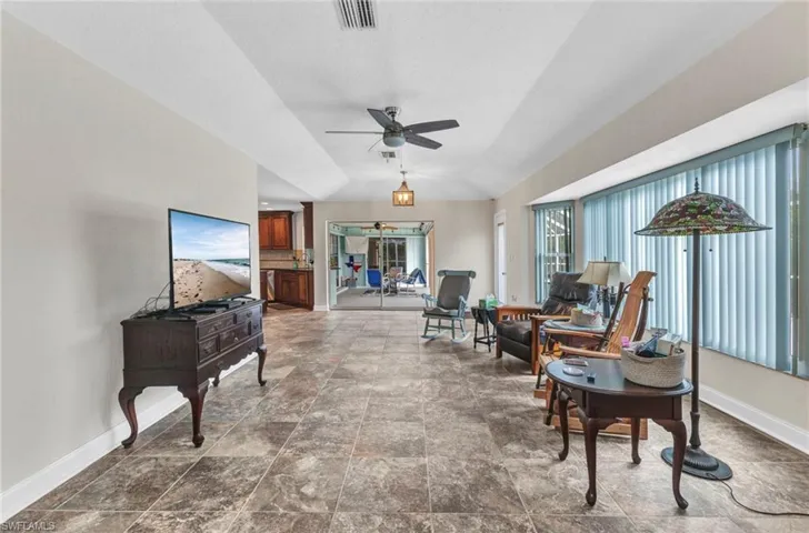 Living area featuring visible vents, baseboards, and a ceiling fan