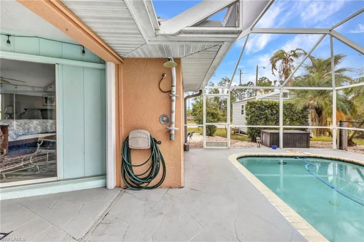 View of pool featuring a patio area and glass enclosure