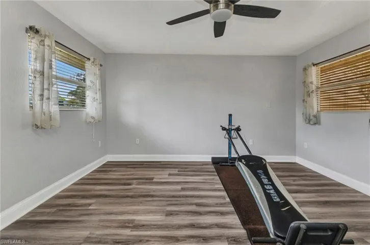 Workout room featuring baseboards and wood finished floors