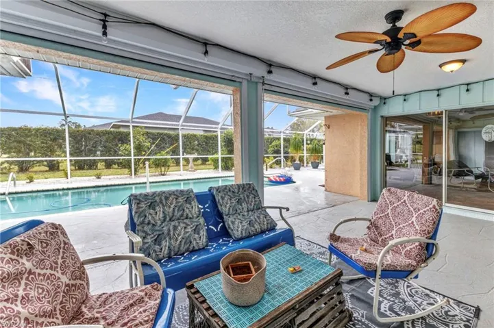 View of patio / terrace featuring a lanai, an outdoor pool, and a ceiling fan