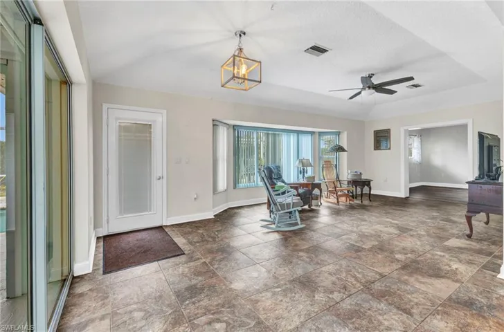 Foyer with visible vents, baseboards, and ceiling fan with notable chandelier