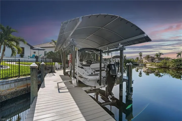 Dock area with a water view, fence, and boat lift