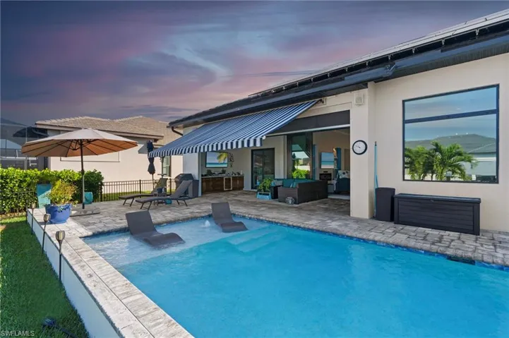 Pool at dusk with fence, an outdoor hangout area, a patio area, and a fenced in pool