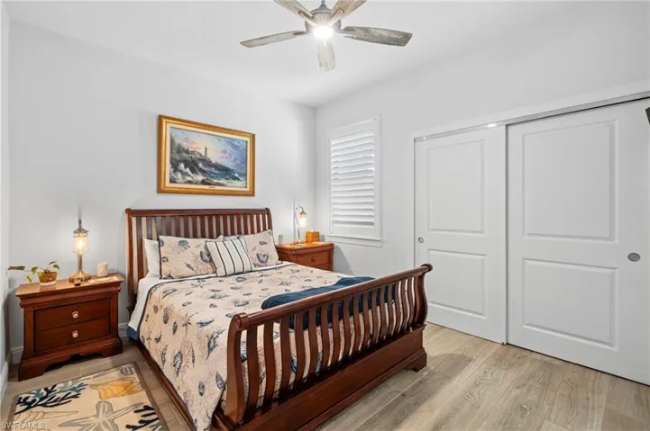 Bedroom with light hardwood / wood-style floors, a closet, and ceiling fan