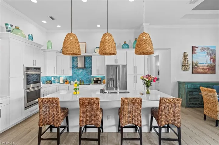 Kitchen with appliances with stainless steel finishes, a breakfast bar, and a large island with sink