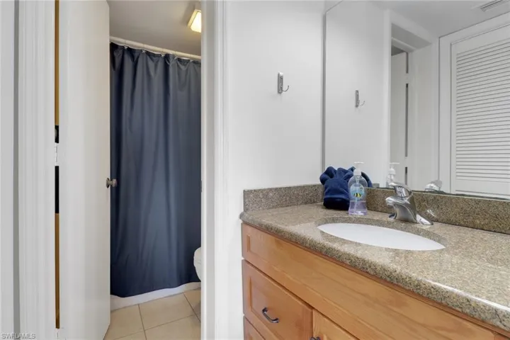 Full bath featuring tile patterned floors, toilet, vanity, and a shower with shower curtain