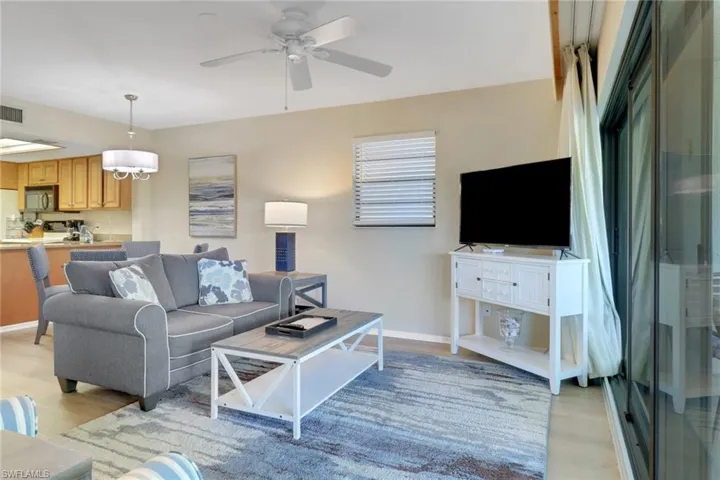 Living room featuring light wood-style floors, ceiling fan, and baseboards