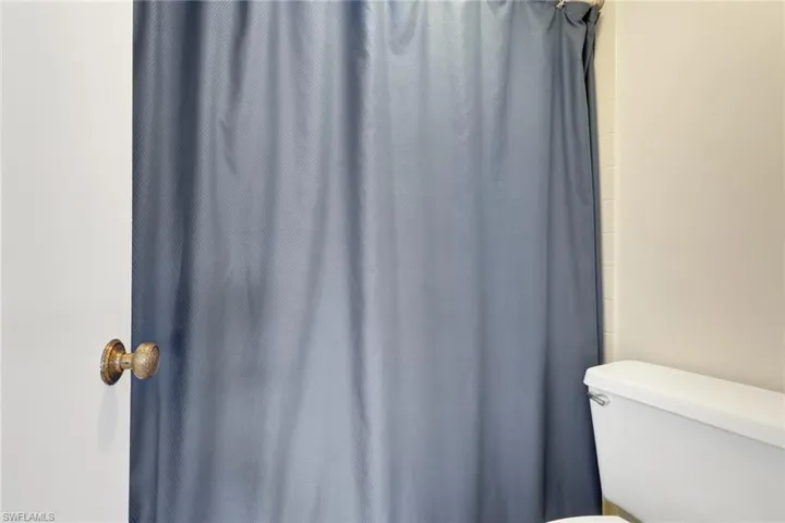 Bathroom with toilet and a shower with shower curtain