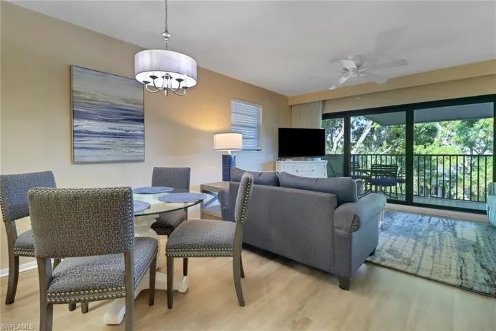 Dining space with light wood-style floors, a ceiling fan, and a chandelier