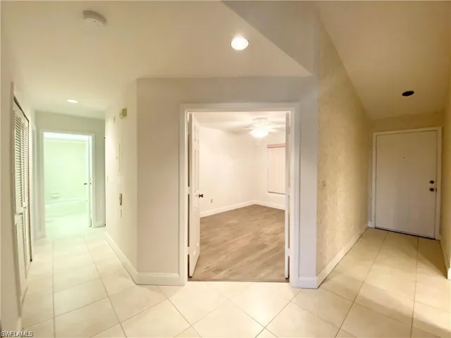 Hallway featuring recessed lighting and light tile patterned floors