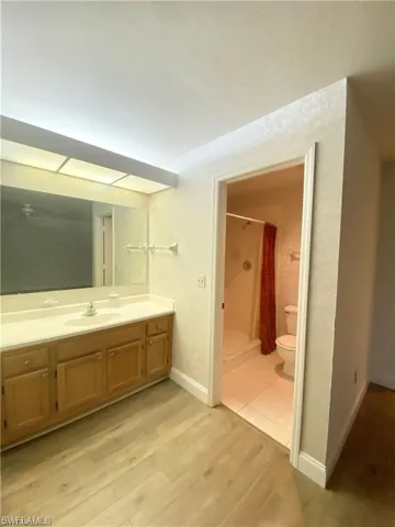 Full bathroom with a shower stall, light wood-type flooring, and vanity