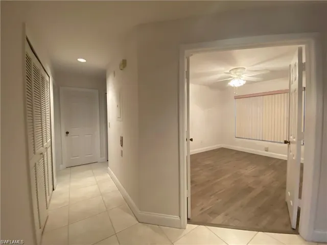 Hall with recessed lighting and light tile patterned floors