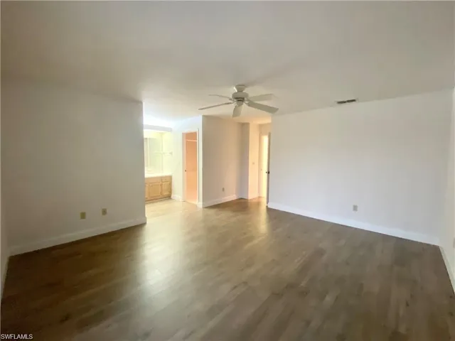 Spare room featuring a ceiling fan and dark wood-type flooring