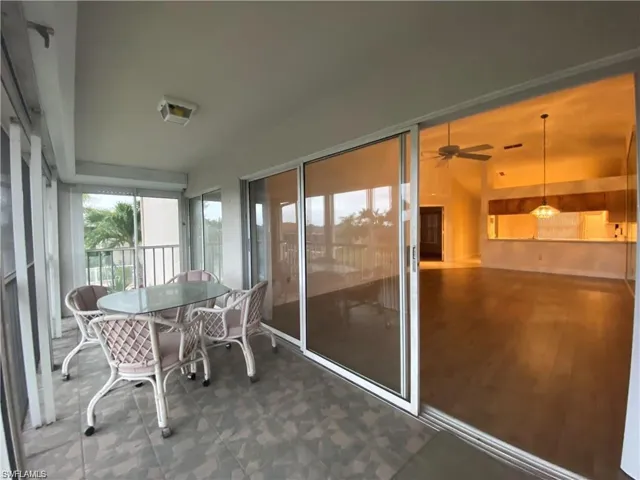 Sunroom with outdoor dining area and a ceiling fan