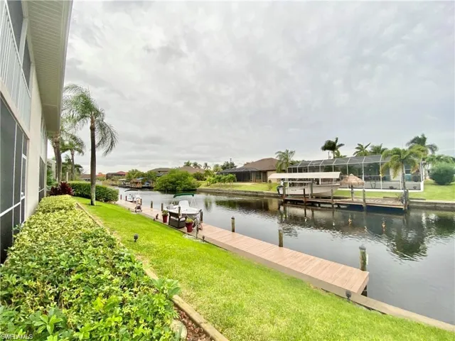 Dock featuring a lawn and a water view