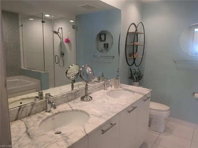Full bathroom featuring tile patterned flooring, shower with separate bathtub, vanity, and toilet