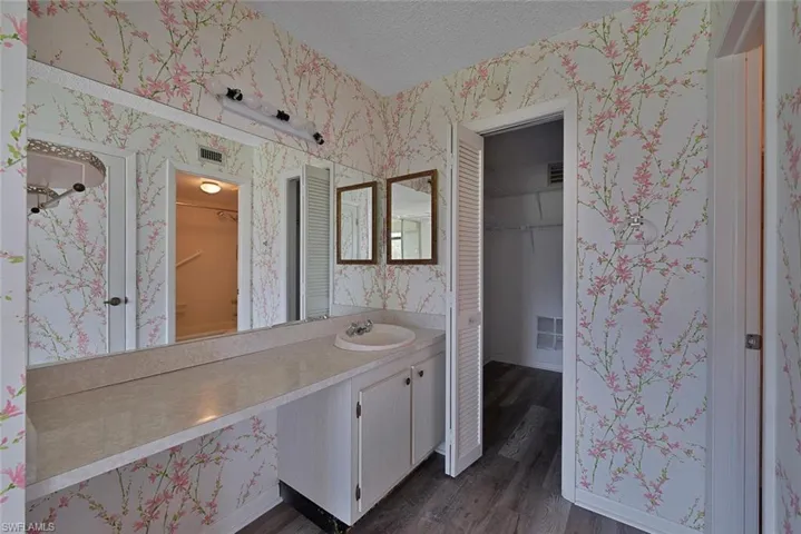 Bathroom featuring vanity, a textured ceiling, and hardwood / wood-style floors
