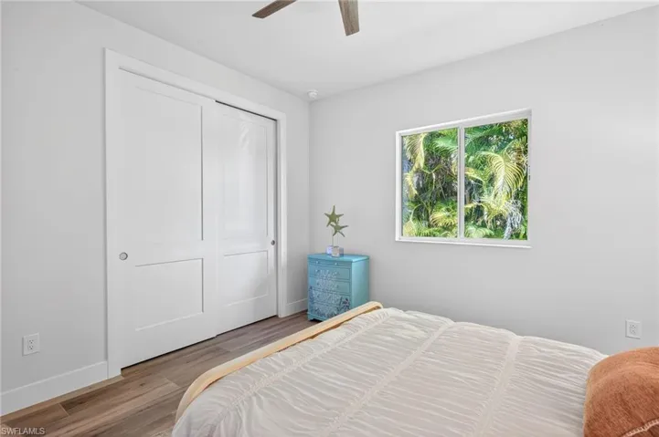 Bedroom featuring wood finished floors, a closet, and a ceiling fan