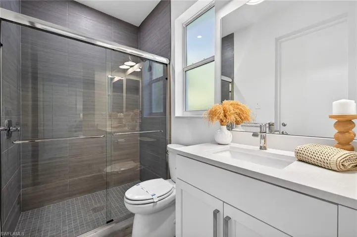 Full bathroom with vanity and a shower stall
