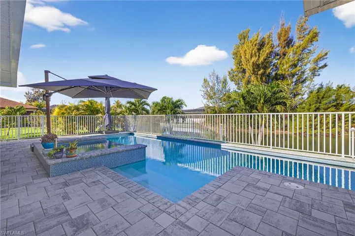 Integrated pool / hot tub featuring a fenced backyard and a patio area