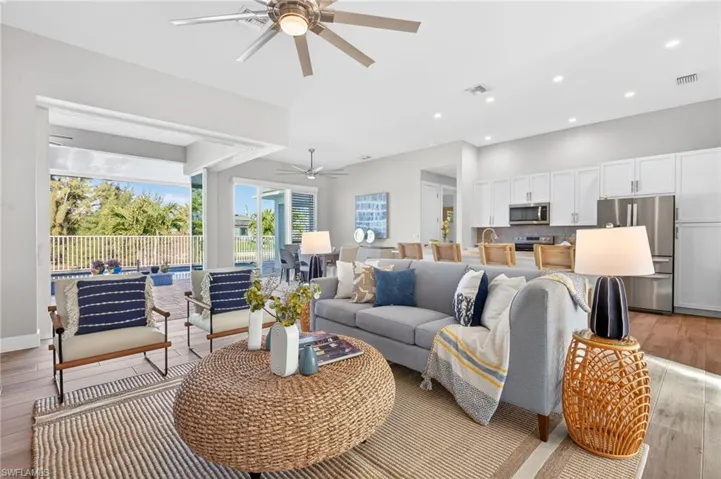 Living area featuring light wood-style flooring, a ceiling fan, and recessed lighting