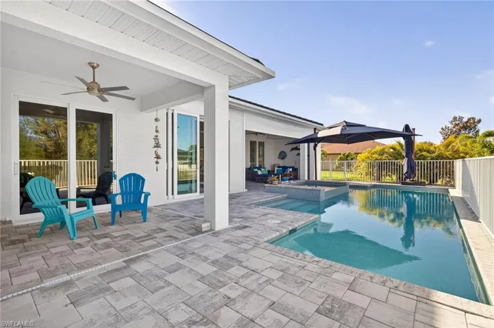 Combined pool / hot tub with a patio area and a fenced backyard