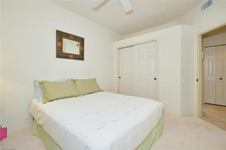 Bedroom with light carpet, a closet, and a ceiling fan