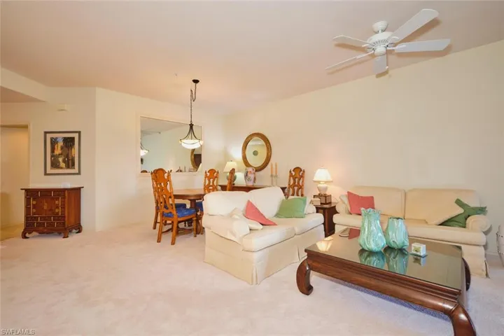 Carpeted living room with ceiling fan