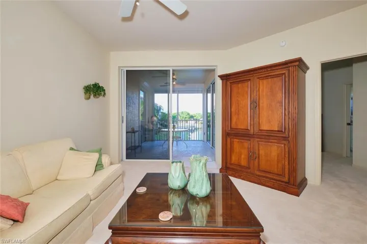 Living area with light colored carpet and a ceiling fan