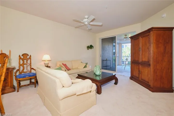 Living room with light carpet and ceiling fan