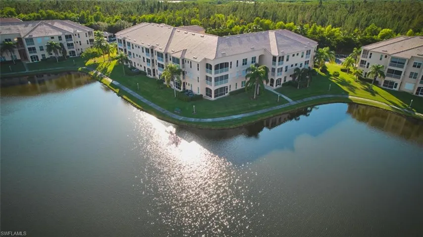 Drone / aerial view of a heavily wooded area and a large body of water