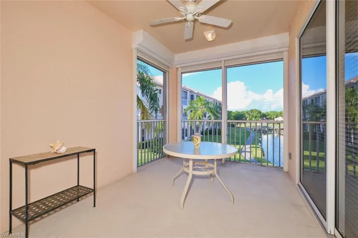 Sunroom / solarium with carpet flooring and a water view